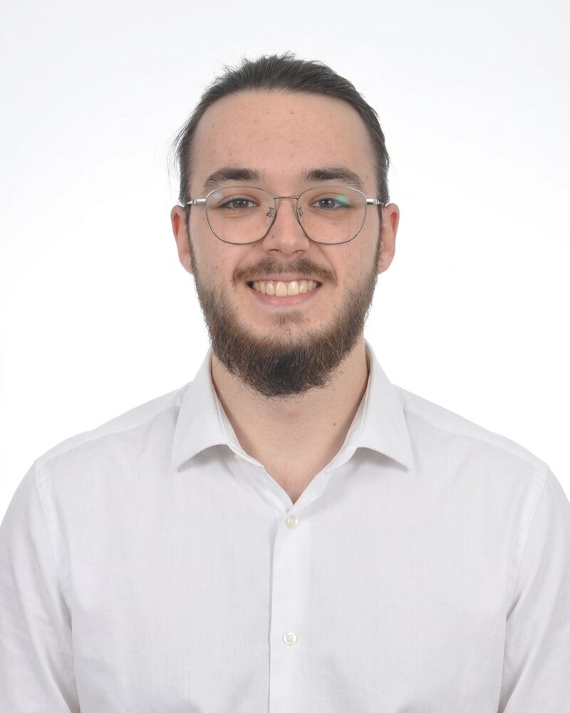 Retrato de Octavio Gregorio sonriendo, con gafas y camisa blanca